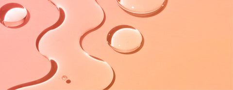 Lifestyle image of water on a surface, orange and pink background