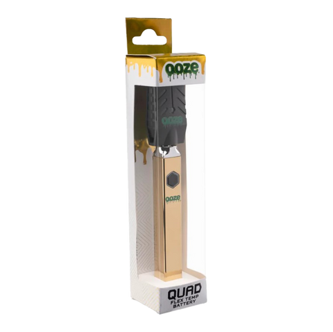 Ooze Quad 510 vape device in gold with attached black USB charger. in gold, white, and clear packaging.